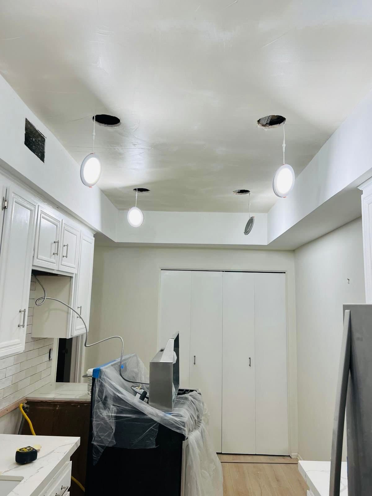Freshly remodeled kitchen with white cabinets and modern lighting, showcasing quality construction by CRGM Builders.